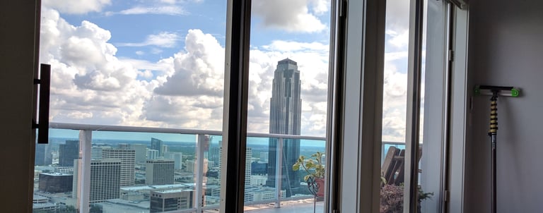 Cleaned windows from a high rise apartment overlooking the city of Houston on a bright blue day