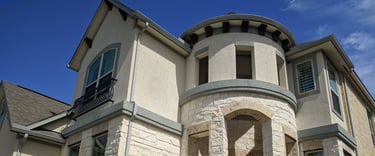 A two story beige stone brick home sparkling and spotless after receiving window cleaning services